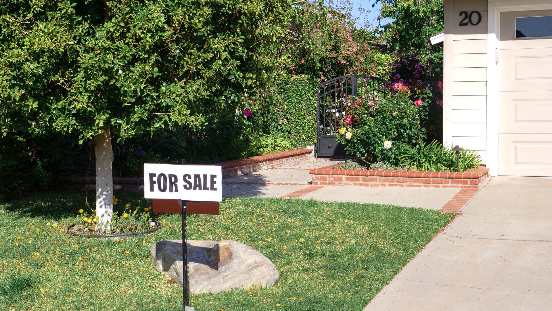House with a for sale sign in the front yard