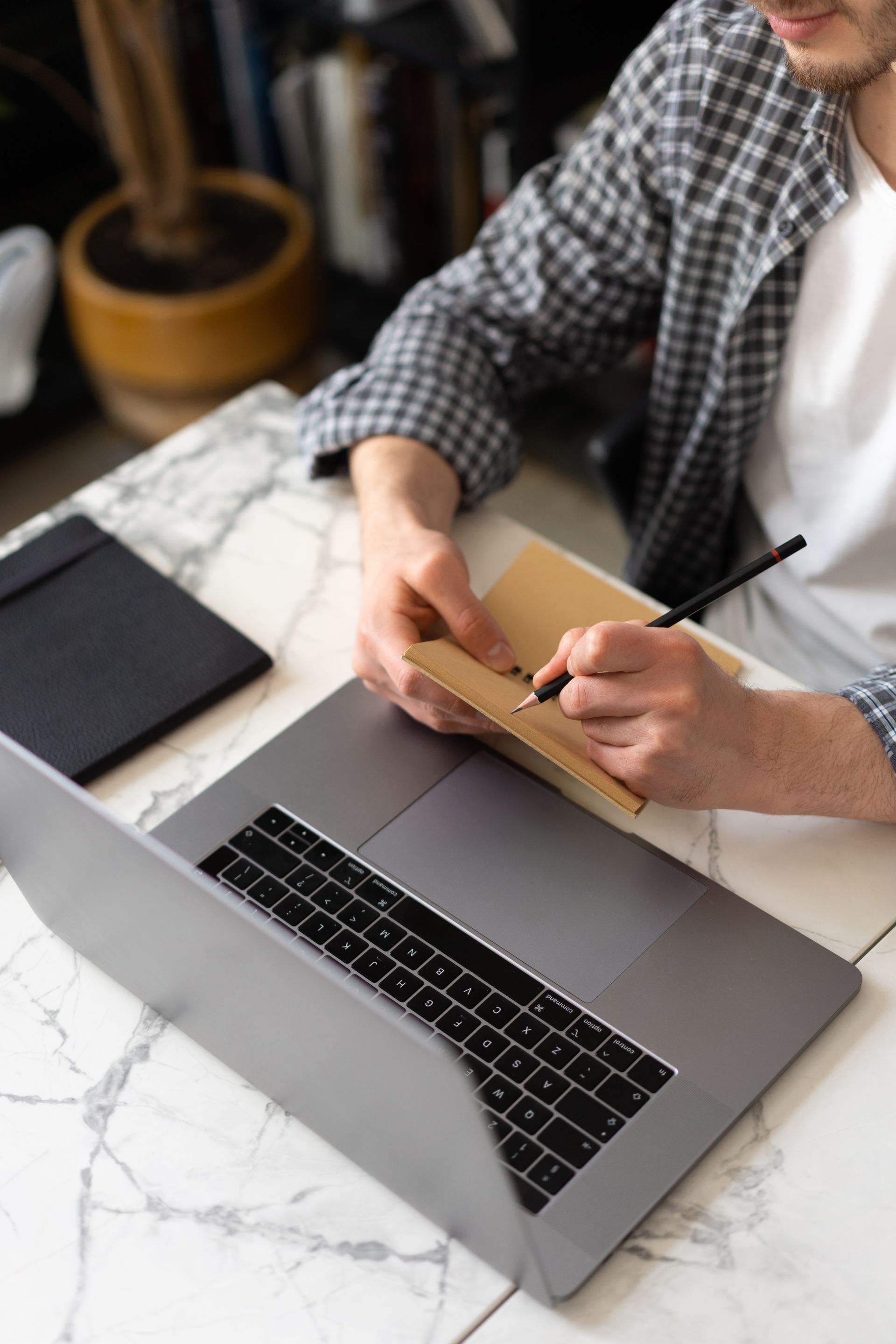 Student taking notes while working through an online course